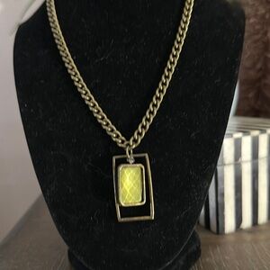 Vintage brass chain with square pendent with green glass bead inside it turns